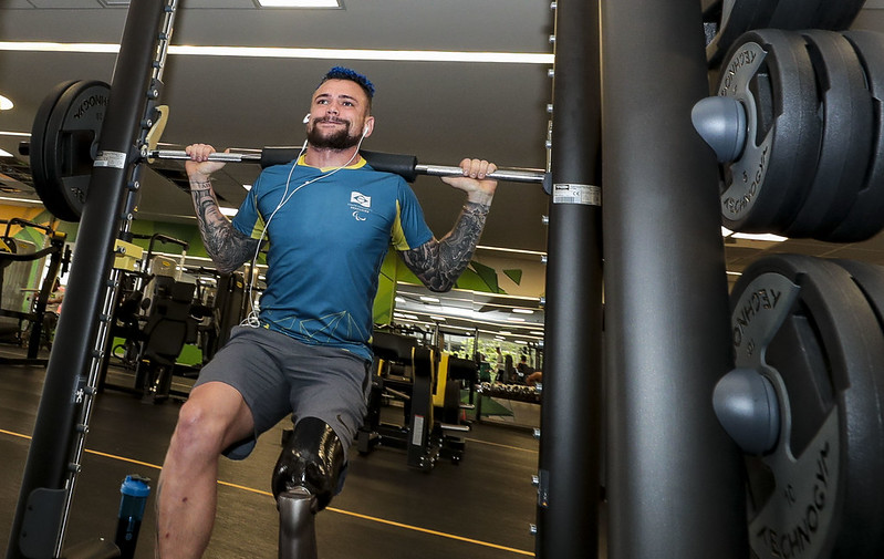 atleta usando prótese na perna esquerda faz levantamento de peso em academia no CT Paralímpico