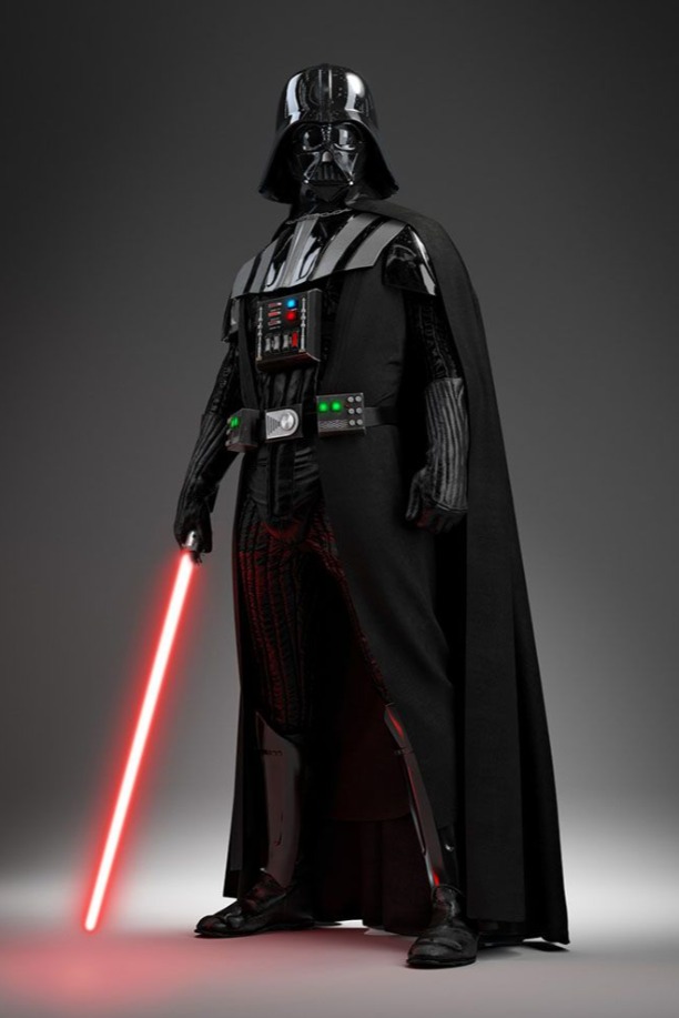 Darth Vader usa uma roupa inteiriça preta com detalhes em cinza nas mãos, e no peito, capa preta, máscara e capacete pretos. Na mão, Darth Vader segura seu sabre de luz vermelho.